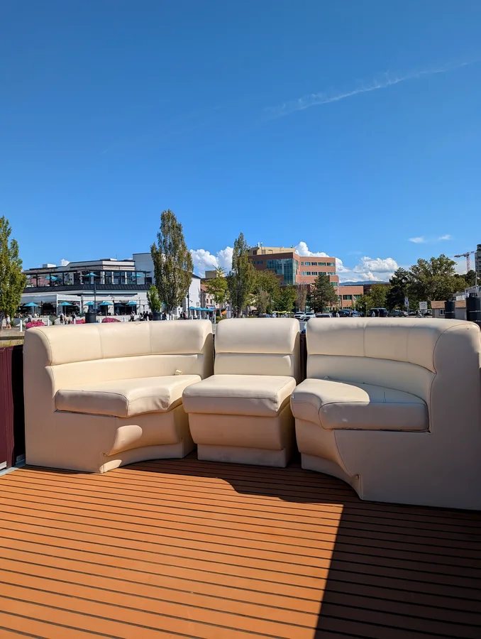 Upper sun deck lounge seating on the double decker pontoon, downtown Kelowna behind